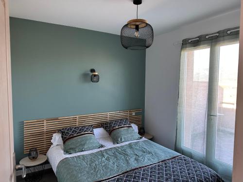 une chambre avec un lit aux murs bleus et une fenêtre dans l'établissement Maison Calenzana, à Calenzana