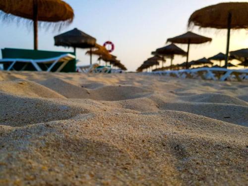 a sandy beach with umbrellas and chairs on it at T1 Manta Rota in Manta Rota