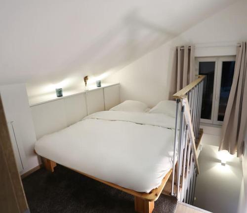 ein weißes Bett in einem Zimmer mit Fenster in der Unterkunft duplex chaleureux avec spa privé in Straßburg