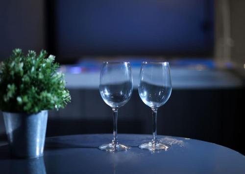 deux verres à vin assis sur une table avec un vase dans l'établissement duplex chaleureux avec spa privé, à Strasbourg