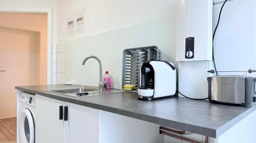 a kitchen with a sink and a counter top at Neumünster Apartments direkt an der Stadthalle mit WLAN & Parkplatz in Neumünster