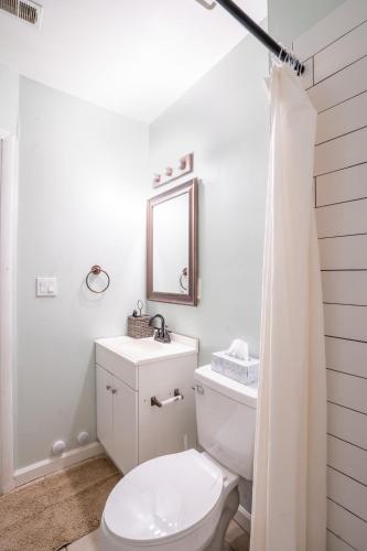 a white bathroom with a toilet and a mirror at Your home away from home in the heart of the city in Atlanta