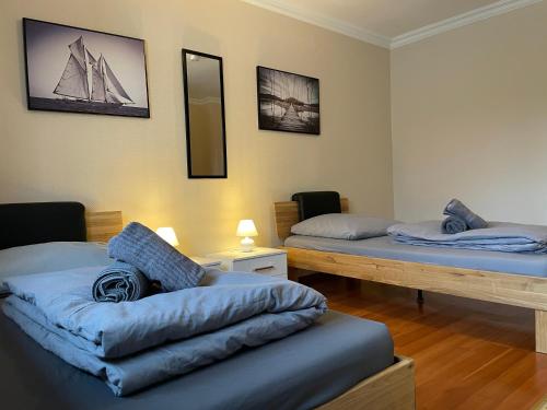 a room with two beds and a couch in it at Parkplätze, Einzelbetten, 2 TVs, Balkon, Terrasse, fast Wi-Fi bis zu 1000 Mbit, Homeoffice in Rodenbach