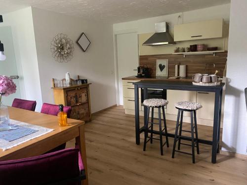 a kitchen with a table and two bar stools at Sunway Lounge in Maishofen