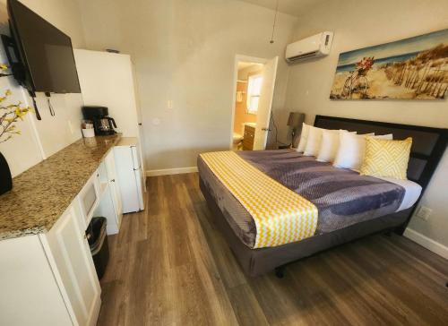 a small bedroom with a bed and a kitchen at Johns Pass Beach Motel in St Pete Beach