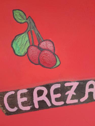 a drawing of two cherries on a red background at Posada Marisel in Chapadmalal
