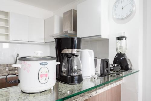 a kitchen counter with a coffee maker and a clock at Skyliving Towers Apartments - Perú in Lima