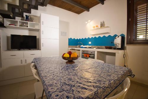 a kitchen with a table with a bowl of fruit on it at Baglio Antico Forno in Ustica