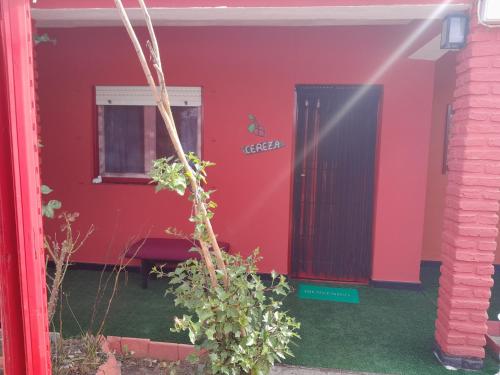 a red house with a black door and a window at Posada Marisel in Chapadmalal
