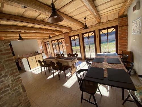 a dining room with a table and chairs and windows at Veronka Vendékház Gombosszeg in Gombosszeg