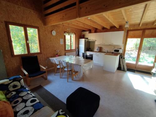 a kitchen and living room with a table and chairs at Gîte Chalet Morvan Bourgogne in Corancy
