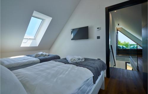 two beds in a room with a window and a tv at Lovely Home In Bedenica With Jacuzzi in Bedenica