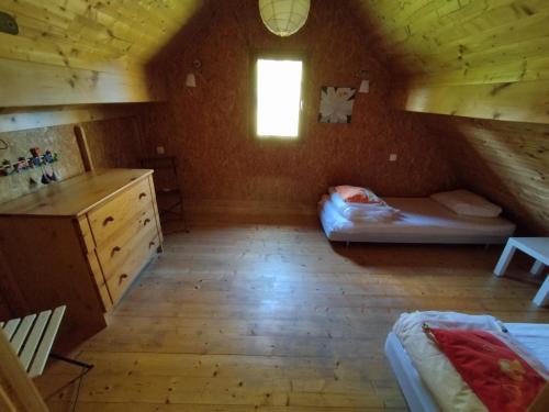 a attic room with a bunk bed and a window at Gîte Chalet Morvan Bourgogne in Corancy