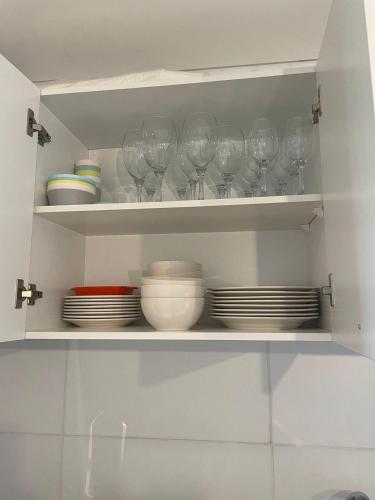 a shelf with wine glasses and plates on it at Departamento Fortaleza Boggiani in Asuncion