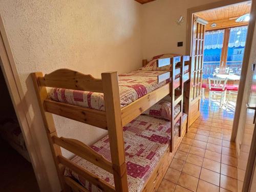2 Etagenbetten in einem Zimmer mit einem Tisch in der Unterkunft Chalet charmant avec balcon sud et Multi Pass à 3€/jour! - FR-1-692-22 in La Chapelle-dʼAbondance