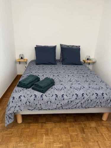 une chambre avec un lit avec deux oreillers dessus dans l'établissement L'Olivette, à Aubenas