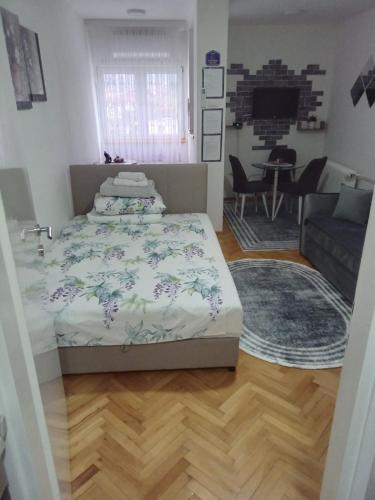 Un dormitorio con una cama y una sala de estar. en Jugi, en Novi Pazar