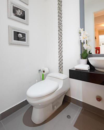 a white bathroom with a toilet and a sink at Skyliving Towers Apartments - Perú in Lima