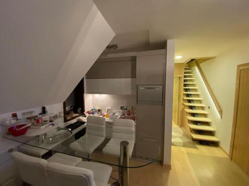 科帕奥尼克Vila Pahulja A10的配有玻璃桌和白色椅子的厨房
