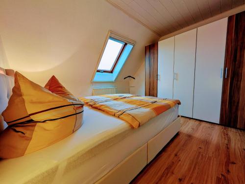 a bedroom with a large bed with a window at Schöne 2-Raumwohnung inklusive Infrarot-Wärmekabine in Großröhrsdorf