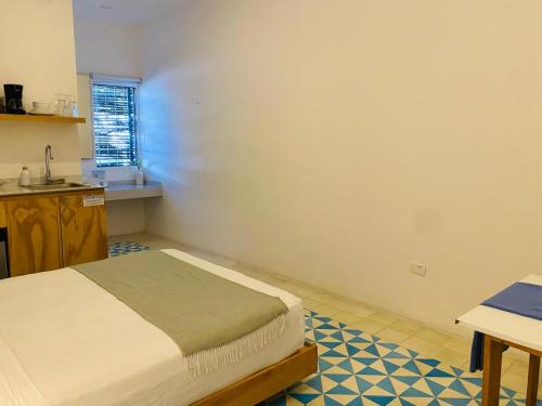 a small bedroom with a bed and a table at Studios Downtown Cancun in Cancún