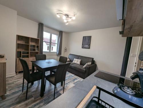 un salon avec une table et un canapé dans l'établissement Chez Paulette, Studio cosy au centre ville de Gérardmer, à Gérardmer