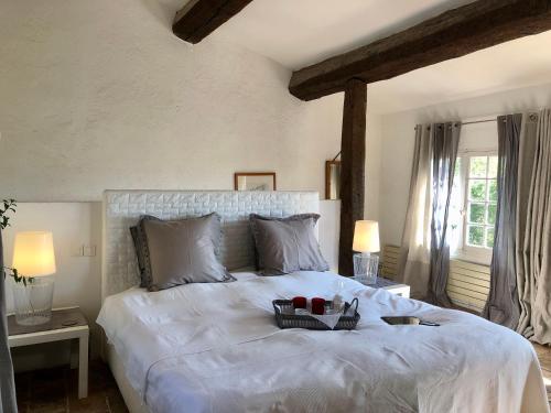 - une chambre avec un grand lit blanc et un plateau dans l'établissement Bergerie de Peymeyan, à Saint-Paul-en-Forêt