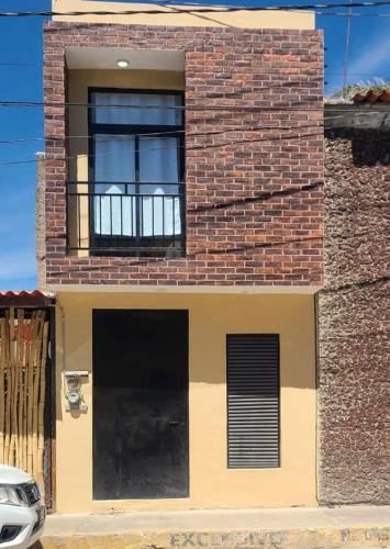 a brick building with a window and a balcony at Departamentos Los 7 Nogales in Tequila