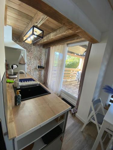 une petite cuisine avec un évier et une fenêtre dans l'établissement Domaine de la Tour Carrée, à Jouy