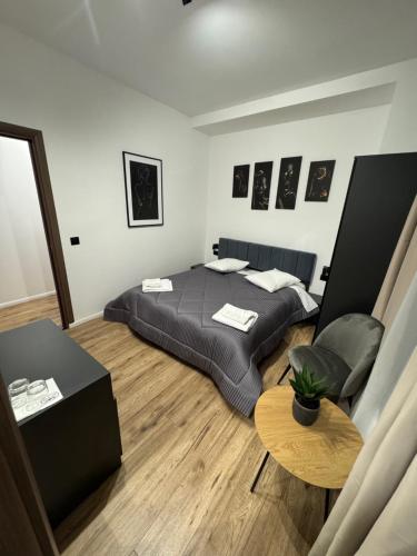 a bedroom with a bed and a table in it at Pensiunea Luisa in Craiova