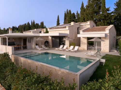 a villa with a swimming pool in front of a house at My Mediterranean Luxury Villas,Corfu in Kontokali