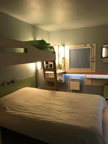 a bedroom with a bunk bed and a mirror at ibis budget L'Isle Adam in LʼIsle-Adam
