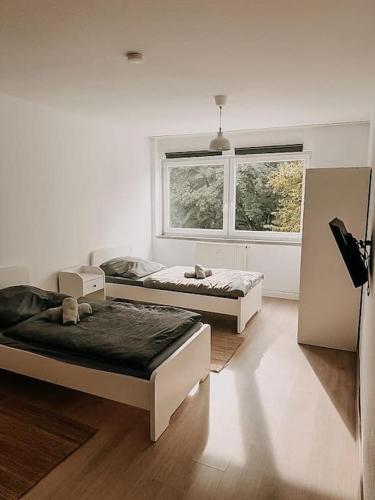 zwei Betten in einem Zimmer mit Fenster in der Unterkunft Wohnen im Ländereck Essen Mülheim Oberhausen BS1HL in Essen