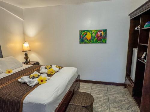 a hotel room with a bed with flowers on it at Caribbean Shores Belize in Hopkins