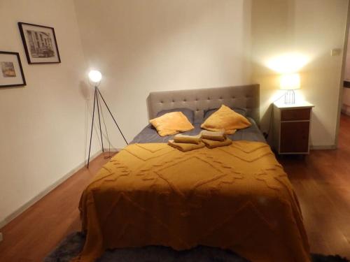 a bedroom with a large bed with two yellow pillows at Maison des oiseaux in Menou