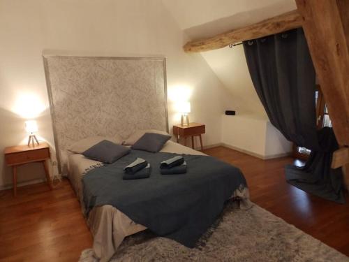 - une chambre dotée d'un lit avec deux chaussures noires dans l'établissement Maison des oiseaux, à Menou