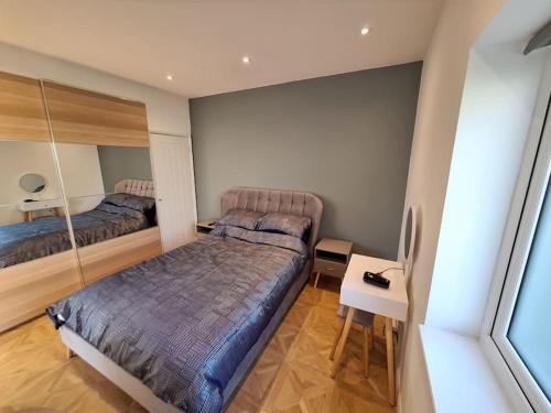 a bedroom with two beds and a desk and a bed at The Lodge at The Elms in Keynsham