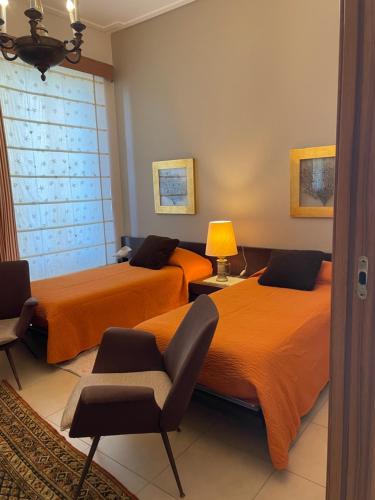 two beds in a room with orange sheets at Domus Felix in Sorrento