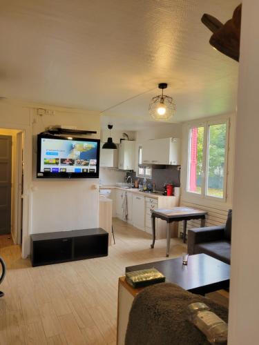 un salon avec une télévision sur un mur dans l'établissement Appartement 4 chambres face carrefour de Stains, à Stains