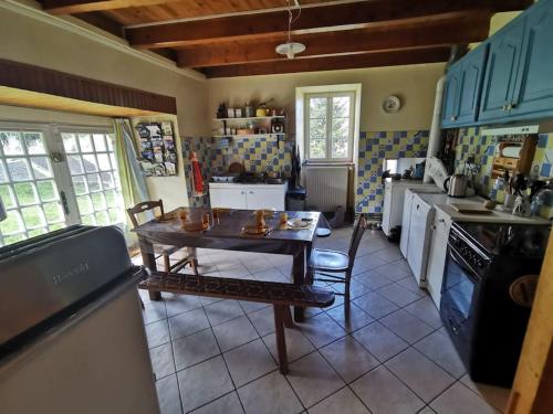 une cuisine avec une table et des chaises dans une pièce dans l'établissement Maison cantalienne typique, à Allanche
