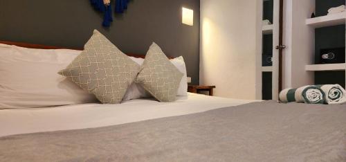 a bed with three pillows on top of it at Hotel Kin Tulum Jungle Deluxe in Tulum