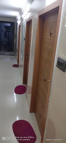 a hallway with three red stools in front of a door at Shree chendur Residency in Tiruvannāmalai
