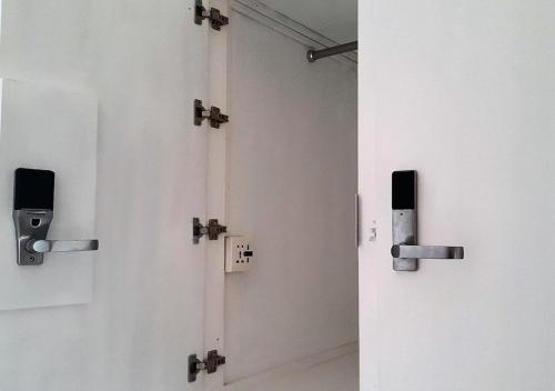 a row of white doors in a room at Traveler's Haven Hostel at Colombo Intl Airport in Katunayake