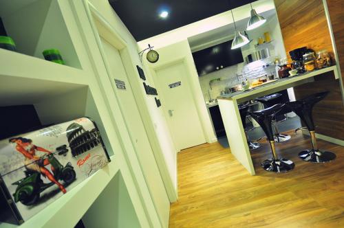 a room with a kitchen and a bar with a motorcycle on the wall at B&B Destinazione Roma in Rome