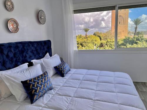 a bedroom with a large bed and a window at La perle de la Tour Hassan- Appartement Rabat in Rabat