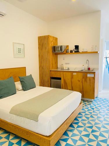 a bedroom with a large bed and a kitchen at Studios Downtown Cancun in Cancún