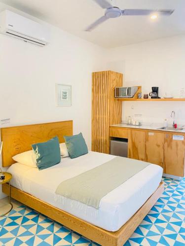 a bedroom with a large white bed with blue pillows at Studios Downtown Cancun in Cancún