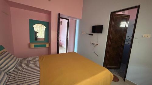 a bedroom with a yellow bed and a pink wall at Breeze valley Residency in Yelagiri