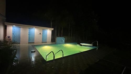 a swimming pool at night with lights in it at Breeze valley Residency in Yelagiri