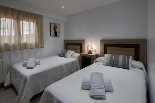 a bedroom with two beds with towels on them at La Villa de Alba - Casa Rural en Montefrío in Montefrío